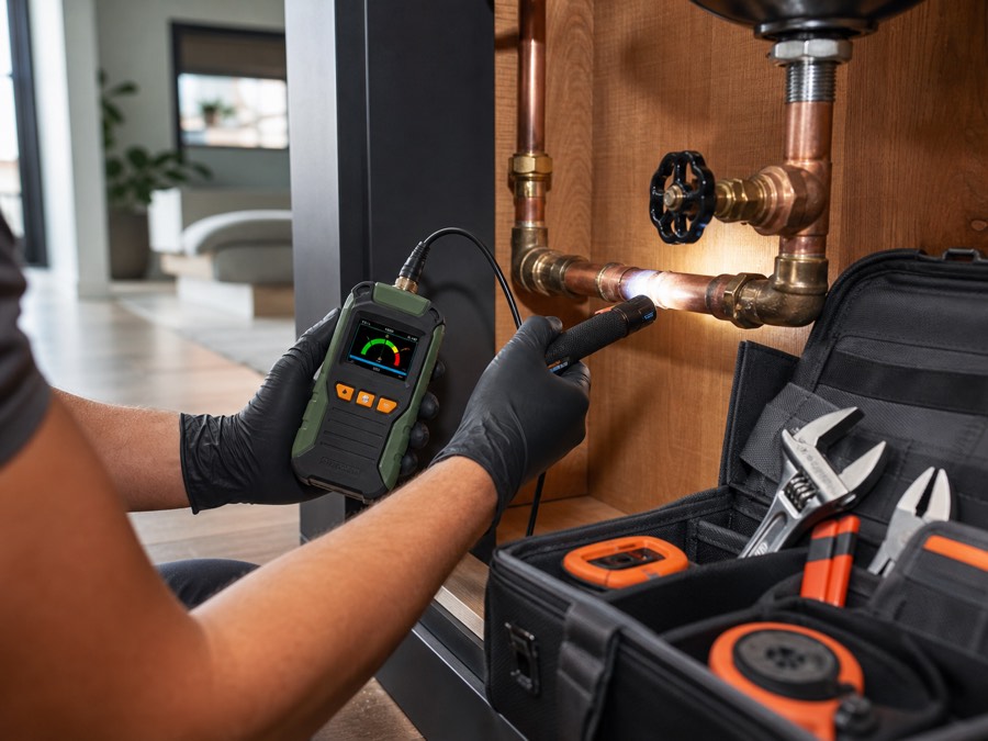 Plumber inspecting a copper pipe connection
